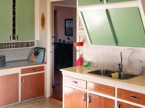 A kitchen with wooden cabinets, a sink, and a countertop.