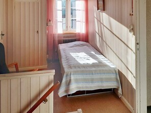 A narrow room with a single bed, a chair, and a radiator. - 7 Person Holiday Home in Oxaback (Öxabäck)