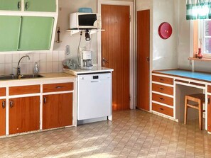 A compact kitchen with a dishwasher, a microwave, and a sink. - 7 Person Holiday Home in Oxaback (Öxabäck)