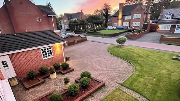 A residential driveway with a brick pathway leading to a house with a brick facade and a small garden area with trimmed bushes and a lawn. - Unwind in Comfort at Cosy Caradus Free Parking (Birmingham)