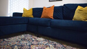 A sectional sofa with multiple cushions in a living room. - Chapel Lodge by Tŷ SA (Newport)