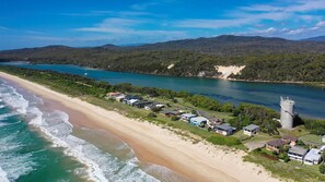 A coastal property with beachfront access, a marina, and a large water tower. - Kokomo - Charming Coastal Escape (Wooli)