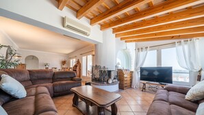 A spacious living room with a brown leather sofa, a wooden coffee table, and a flat-screen TV. - Adriana: House with garden and private pool (L'Escala)