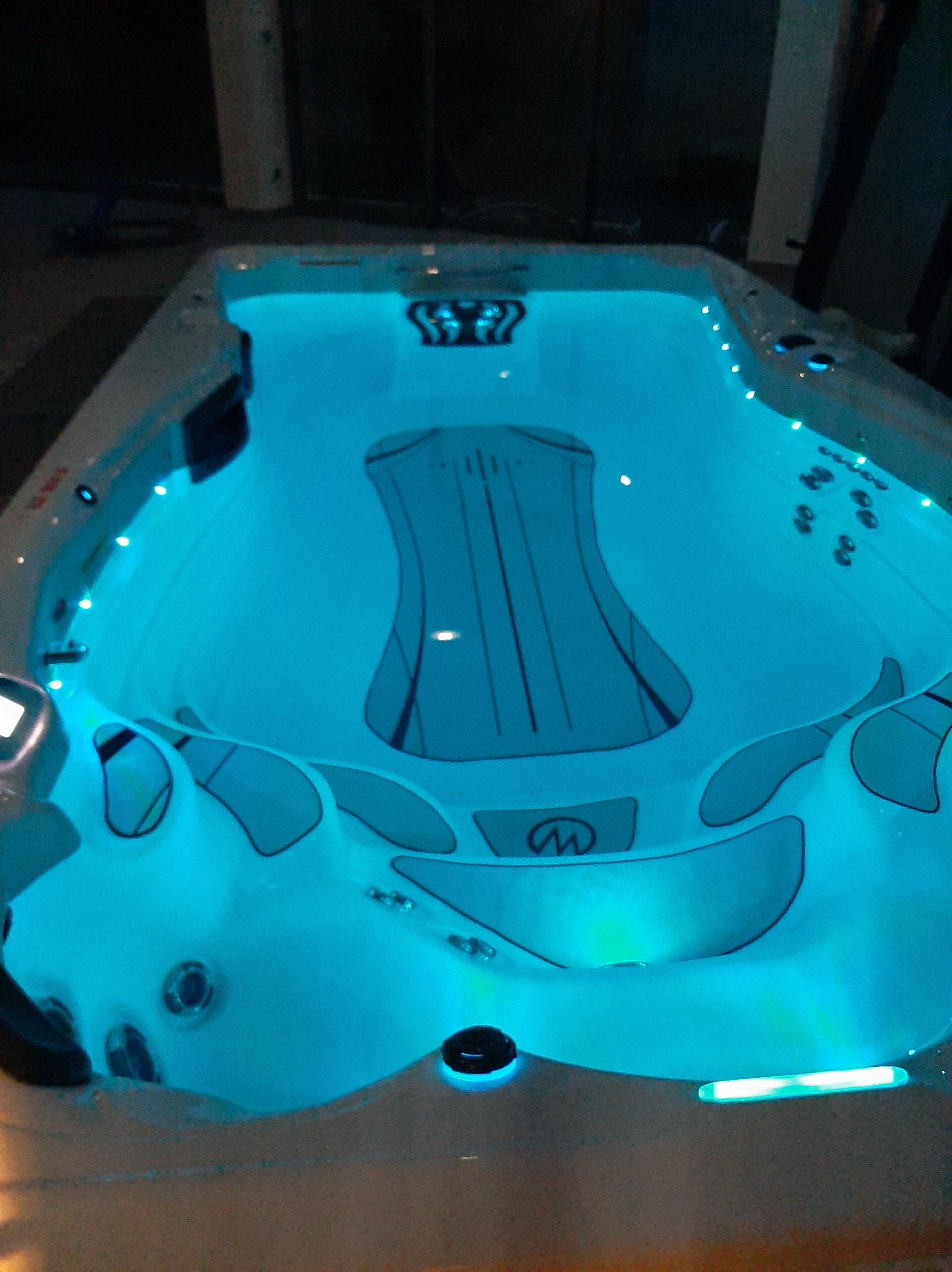 Un jacuzzi con un diseño central y múltiples chorros.