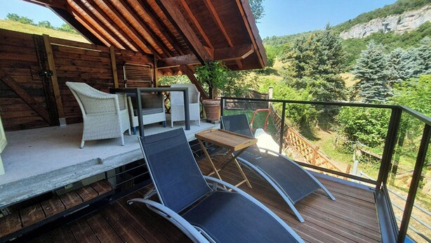 A wooden deck with outdoor furniture, a table, and chairs. - L'Arveysan (Sainte-Marie-d'Alvey)