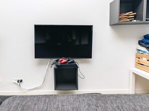 A television mounted on a wall with a small black speaker below it. - 5 Star Holiday Home in Vaeggerlose (Vaeggerlose)
