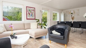 En moderne stue med sofa, lænestol og spiseplads.
