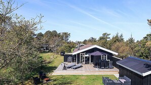 A modern house with a deck, outdoor furniture, and a chimney. - 6 Person Holiday Home in Lokken (Lokken)