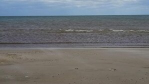 A beach with a sandy shore and calm sea under a cloudy sky. - 6 Person Holiday Home in Lokken (Lokken)