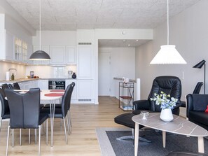 Un appartement moderne comprenant un coin repas, une cuisine et un salon.