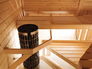 Un interior de madera con una rejilla metálica y una escalera de madera.