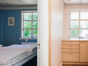 Une chambre à coucher avec un lit, une fenêtre et une commode en bois.