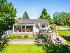 A house with a covered patio, a fenced yard, and a chimney. - 6 Person Holiday Home in Borkop (Borkop)