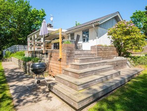 A residential property with a wooden staircase, a barbecue grill, and a covered outdoor seating area. - 6 Person Holiday Home in Borkop (Borkop)