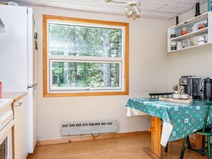 A compact kitchen with a window, a table with a floral tablecloth, and a coffee machine. - 4 Person Holiday Home in Ebeltoft (Ebeltoft)