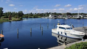 A marina with boats docked, a wooden dock, and houses in the background. - 4 Person Holiday Home in Ebeltoft (Ebeltoft)