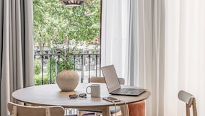 A round table with a laptop, a mug, and a vase with a plant.