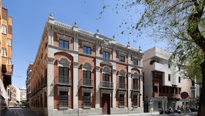 A historic building with a symmetrical facade, large windows, and a central entrance.