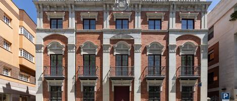 Un edificio histórico con fachada simétrica, varios balcones y una entrada central.