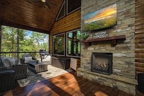 Un patio acogedor con mobiliario de mimbre, chimenea y vistas panorámicas.