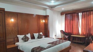 Un dormitorio amplio con una cama grande, cabecera de madera y un escritorio con silla.