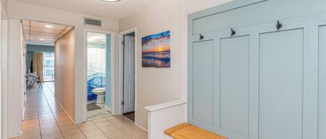 A hallway with a bench, a door, and a painting.