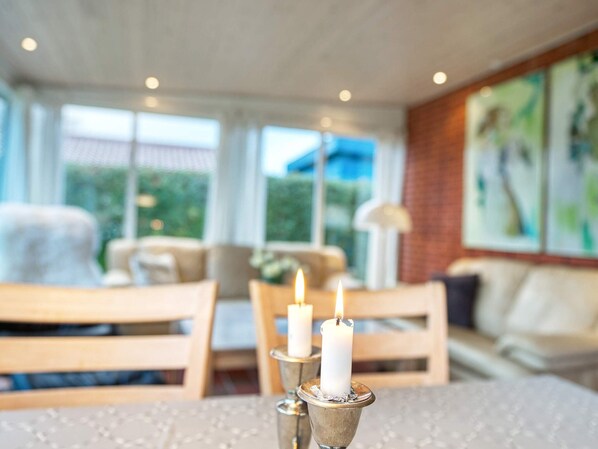 A dining area with a table set for two, featuring a candle centerpiece. - 6 Person Holiday Home in Dannemare (Dannemare)