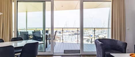 A modern room with a sliding glass door leading to a balcony with a marina view.