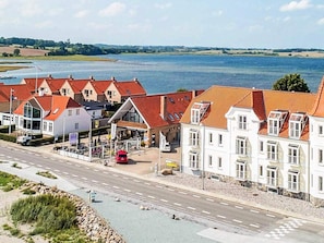 En kuststad med traditionell arkitektur, en huvudgata och en vattenyta i bakgrunden.
