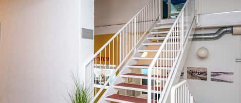 A staircase with white railings leading to an upper floor.