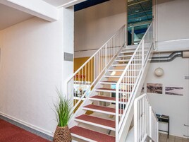 Una escalera con barandillas blancas que lleva a un piso superior.