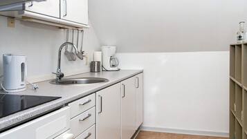 A kitchen with a sink, stove, and cabinets.
