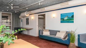 Et moderne interiør med en sofa, et bord og et plakat på væggen.