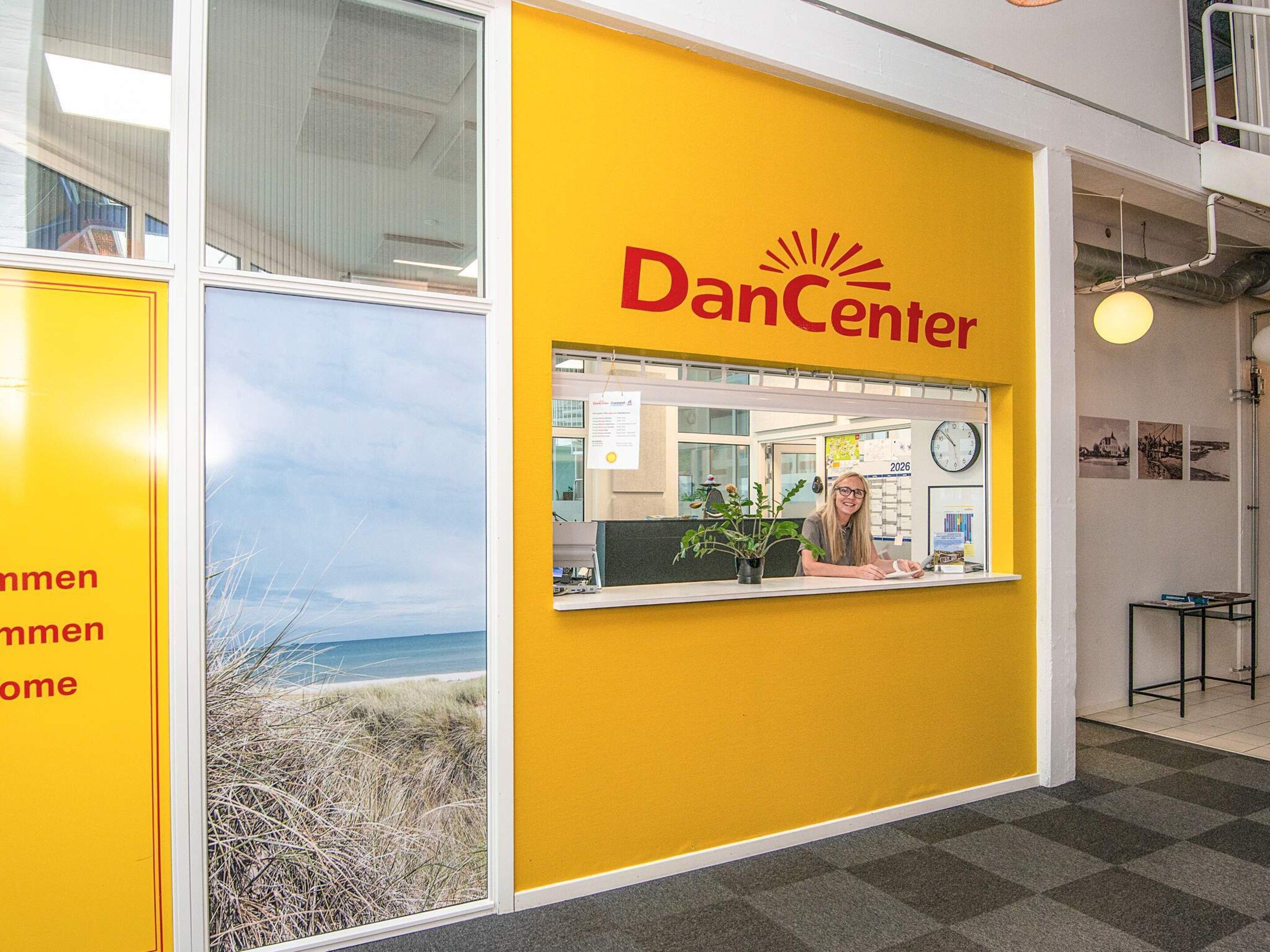 A reception area with a yellow wall and the text 'DanCenter' on it.