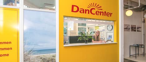 A reception area with a yellow wall and the text 'DanCenter' on it.