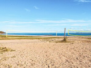 A beach volleyball net with a clear view of the ocean and sky. - 4 Person Holiday Home in Hejls (Hejls)