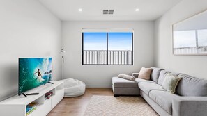 Relax in this stylish living room with a flat-screen TV, comfortable sofa, and cozy bean bag chair.