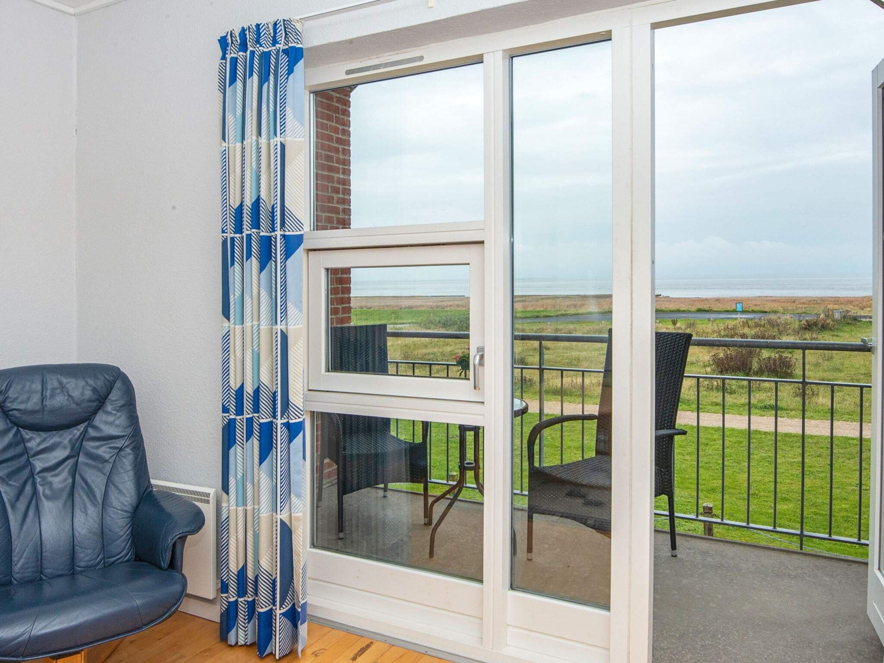Ein Zimmer mit einer Schiebeglasdoor zum Außenbereich mit Blick auf das Meer.