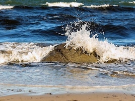 A beach with waves crashing onto the shore.