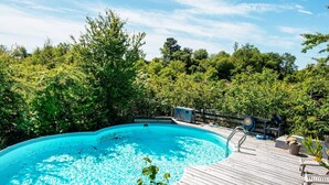 A swimming pool with a wooden deck, surrounded by lush greenery. - 4 Star Holiday Home in Ebeltoft (Ebeltoft)