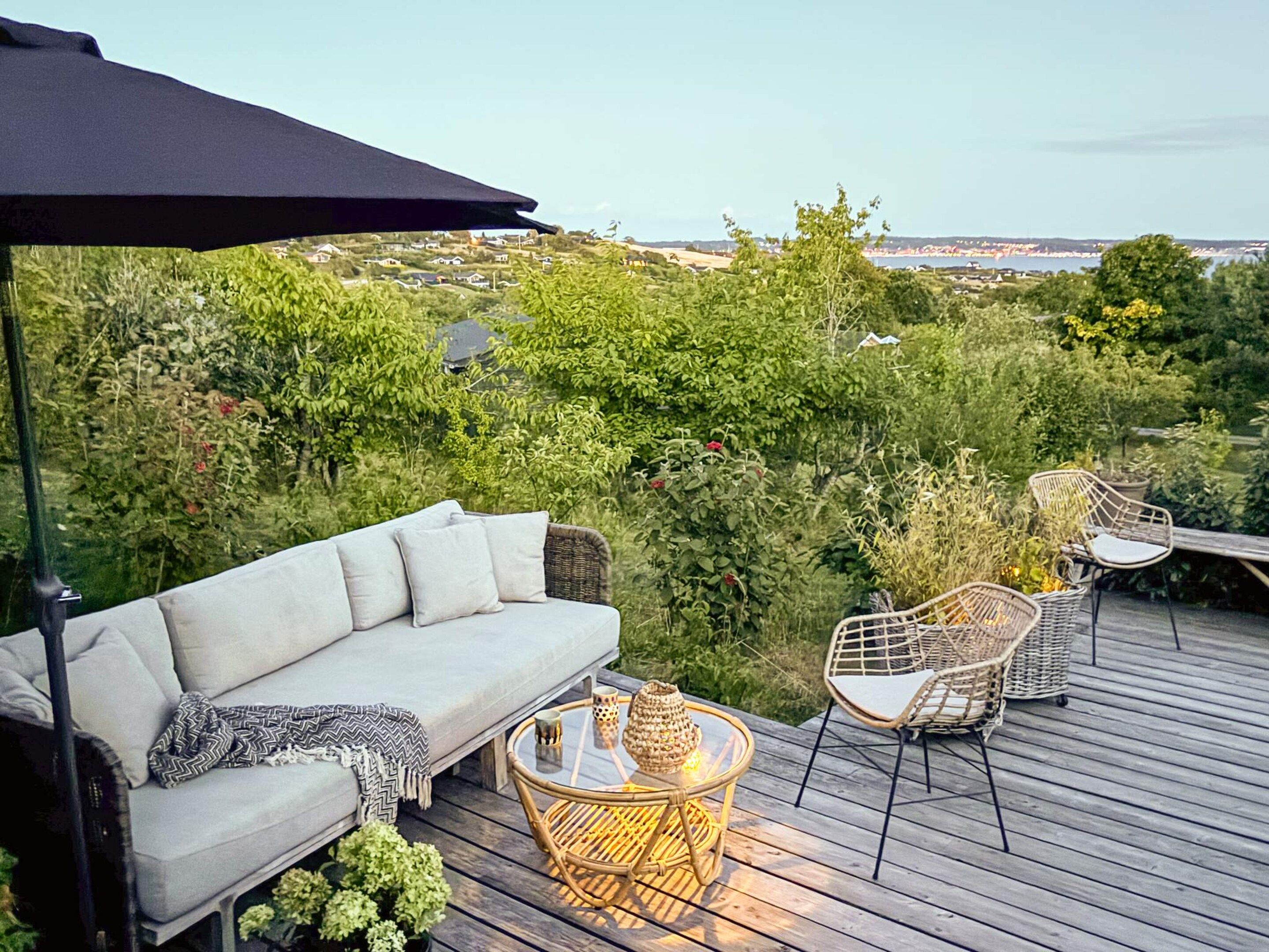 An outdoor deck with a sofa, chairs, and a table.