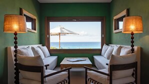 A room with a view of the ocean, two chairs with a table, and lamps. - Dunas de Formentera Hotel (Formentera)