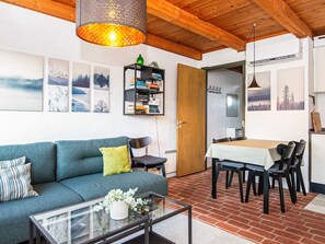 Ein modernes Wohnzimmer mit einer Couch, einem Couchtisch und einem Essbereich mit Stühlen.