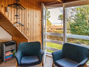 A wooden interior with two chairs, a grill, and a view of the outdoors. - 5 Person Holiday Home in Romo (Rømø)