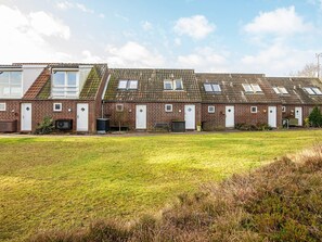 A row of brick houses with multiple windows and a grassy front yard. - 5 Person Holiday Home in Romo (Rømø)