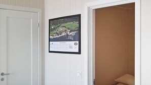 Une chambre à coucher avec un lit, une porte blanche et un tableau encadré accroché au mur.