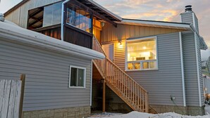 Une maison à deux étages avec un escalier en bois menant à un balcon.