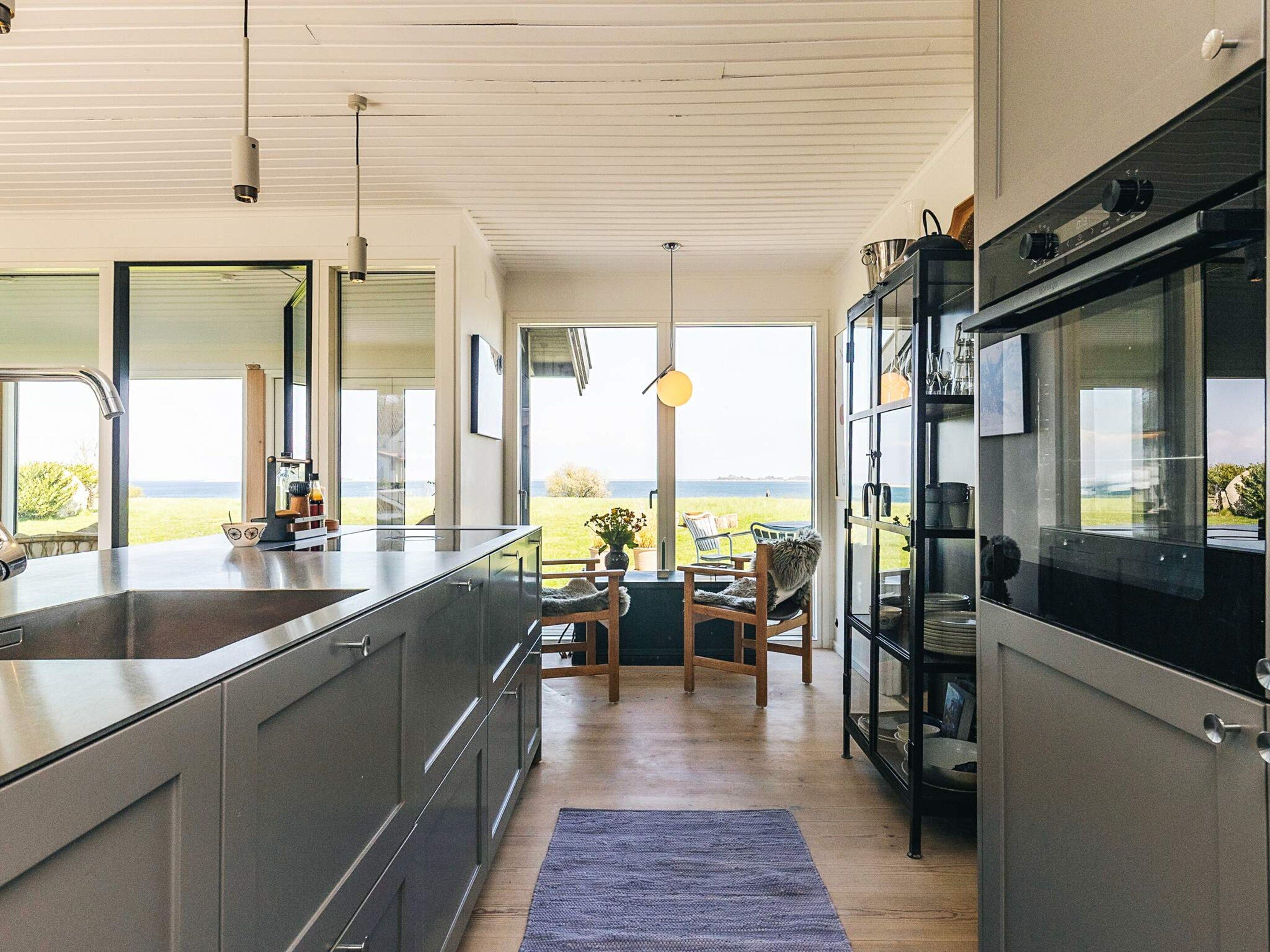 A modern kitchen with a large island, built-in appliances, and a view of the outdoors.