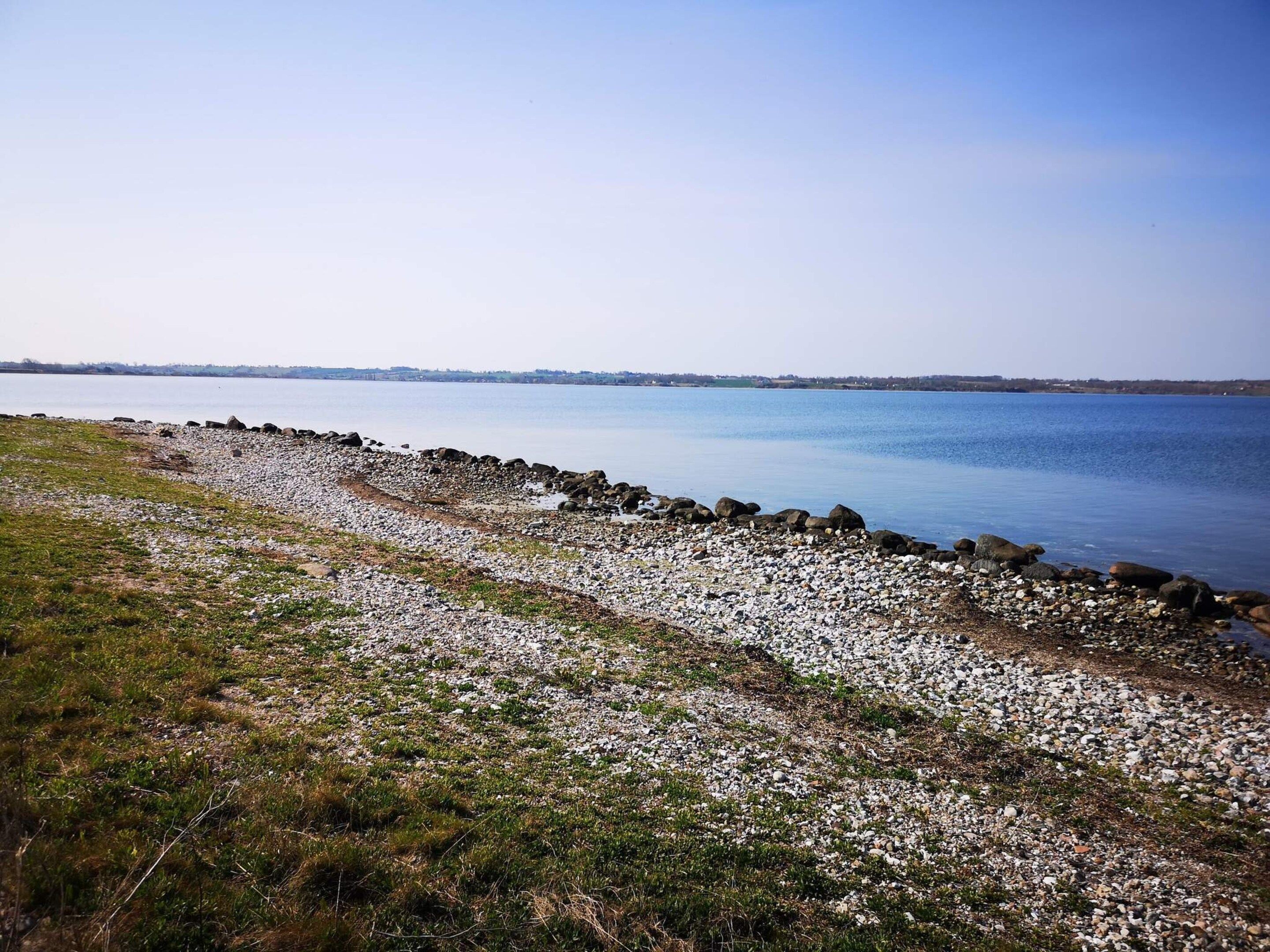 Un paysage côtier caractérisé par une rive rocheuse et une eau calme.
