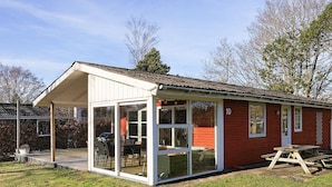 A small, red building with a glass enclosure, a picnic table, and a number '10' on the side. - 4 Person Holiday Home in Hals (Hals)